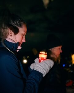 Woman holding a lit candle at night